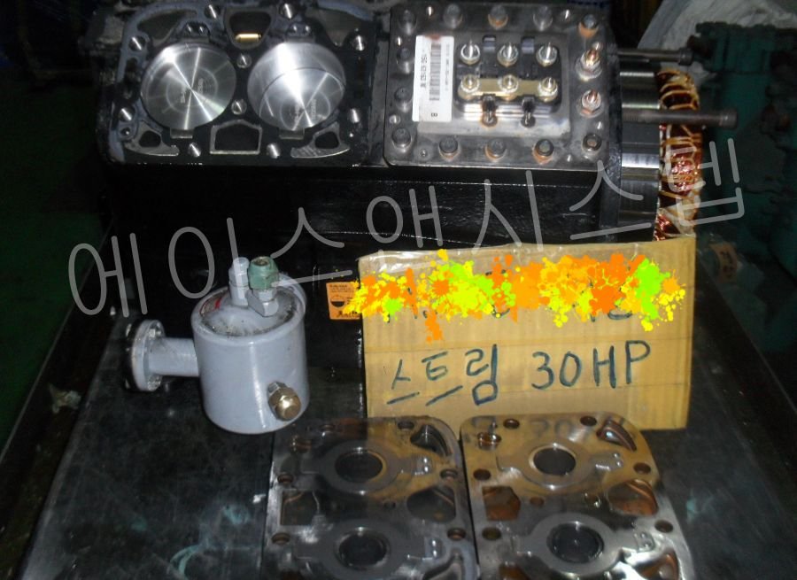 콤프레셔 오버홀 공정 중 손상을 확인하기 위해 분해된 실린더 헤드와 밸브 플레이트