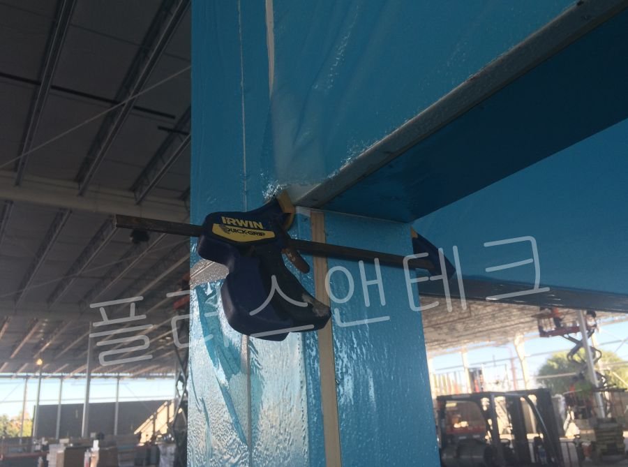 저온저장고 설치과정 중 코너 부위 결합부의 기밀을 완벽히 확보하기 위해 대형 F-클램프를 사용하여 패널을 압착 고정하는 모습