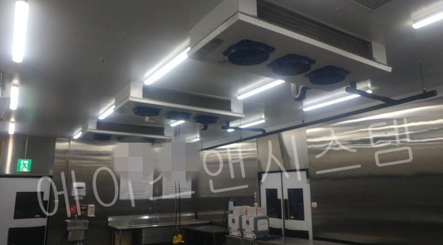 모든 신규 증발기가 일정한 간격으로 깔끔하고 일열로 설치 완료된 냉동창고 내부 전경. 성공적인 시공 완료를 보여주는 사진
