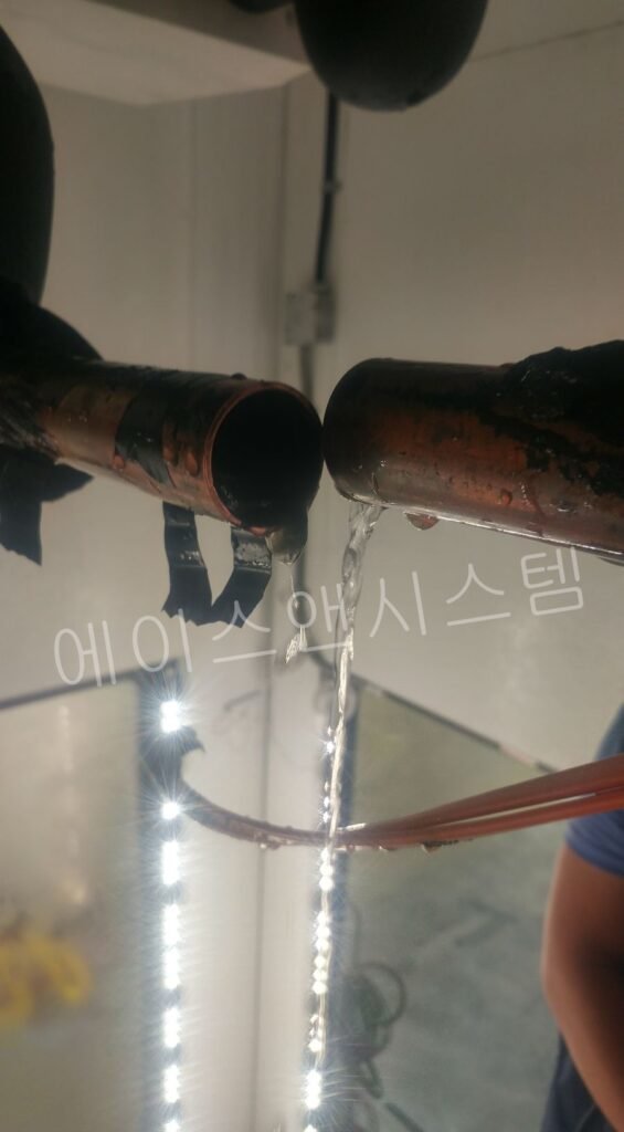 냉동창고 증발기 드레인 배관 청소 후 물을 이용해 배수 상태를 확인하는 모습