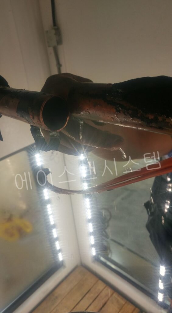 증발기 드레인 배관 내부 오염 상태를 점검하는 모습